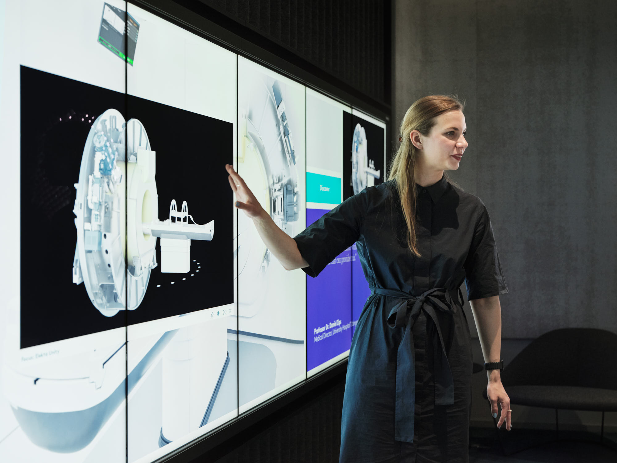 A person standing in front of a screen, giving presentation on the Elekta application